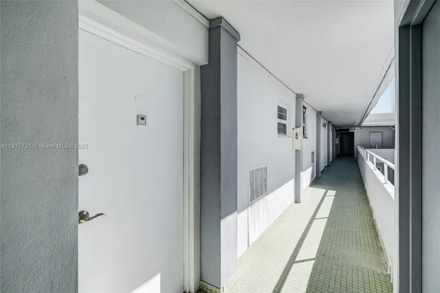 a hallway with white doors wooden floor and stairs