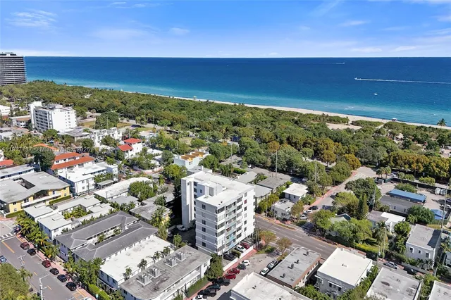 an aerial view of a city with ocean view in back