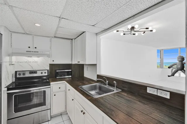 a kitchen with cabinets wooden floor and stainless steel appliances