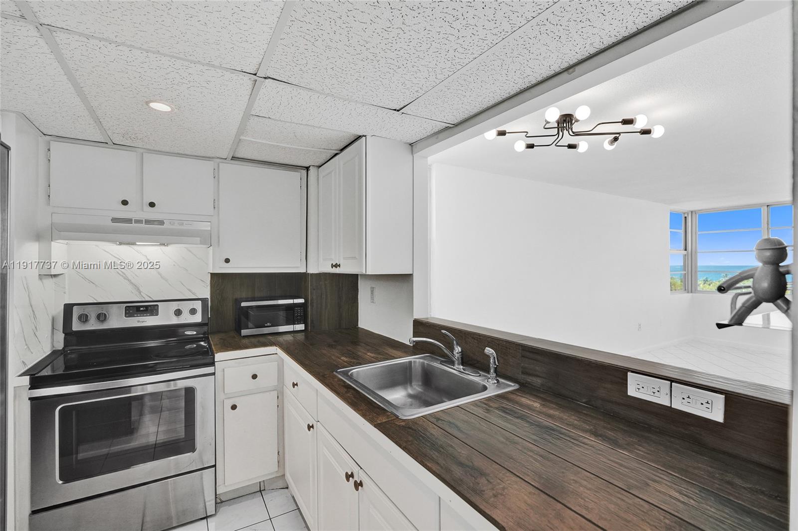 8000 Harding Avenue, Unit 7F Miami Beach, FL 33141 - Photo 6 of 46 a kitchen with cabinets wooden floor and stainless steel appliances