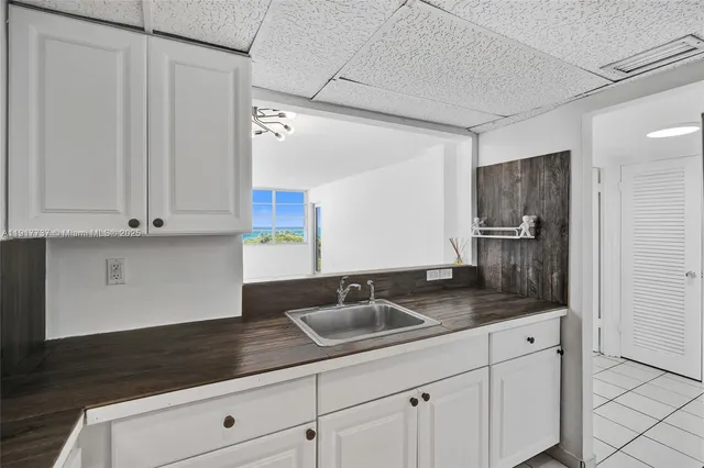 a kitchen with stainless steel appliances granite countertop white cabinets and a sink