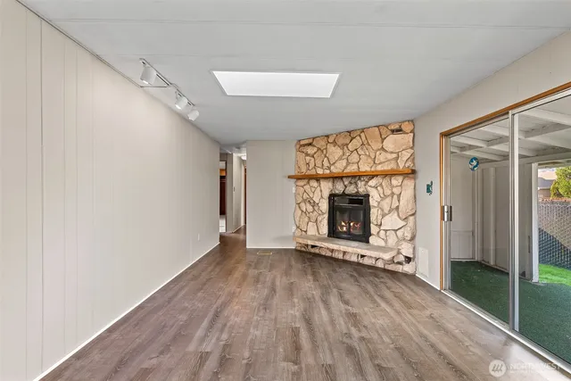a view of an empty room with a fireplace and a window