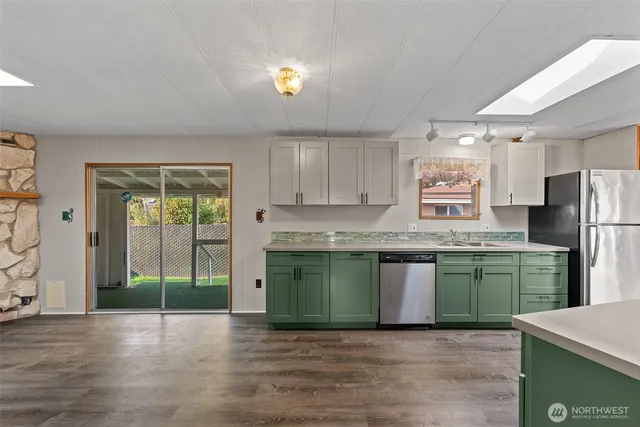 a kitchen with stainless steel appliances granite countertop a refrigerator and a sink