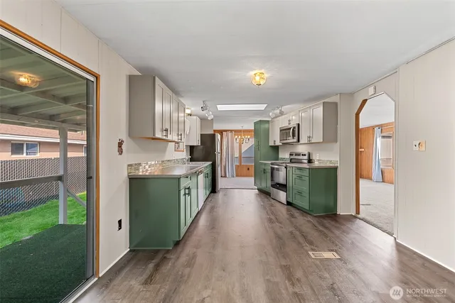 a kitchen with stainless steel appliances kitchen island granite countertop a refrigerator a sink and a stove