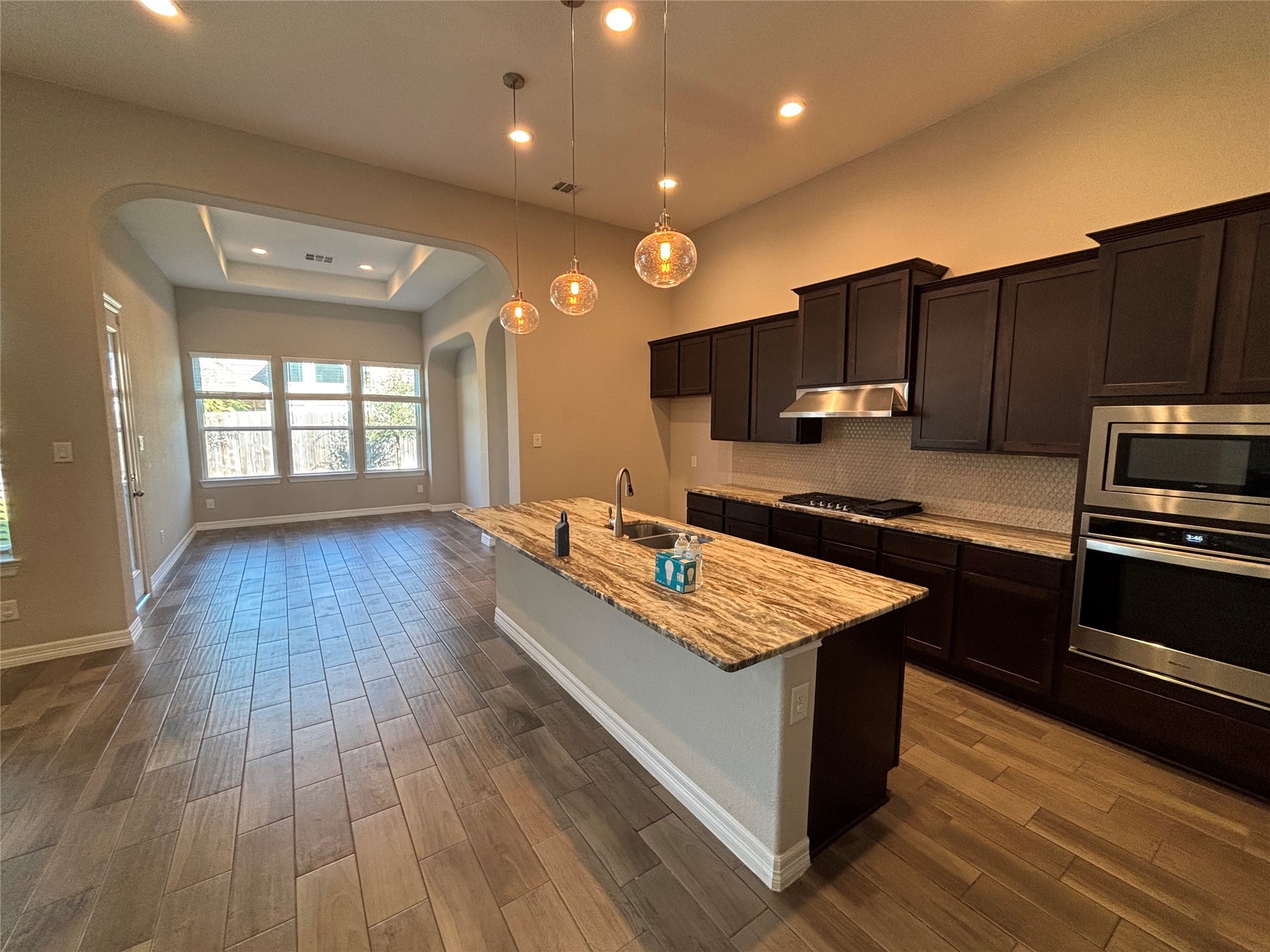 20826 Stonebreak Lane Spring, TX 77379 - Photo 14 of 37 a large kitchen with wooden floors stainless steel appliances a window and a counter space