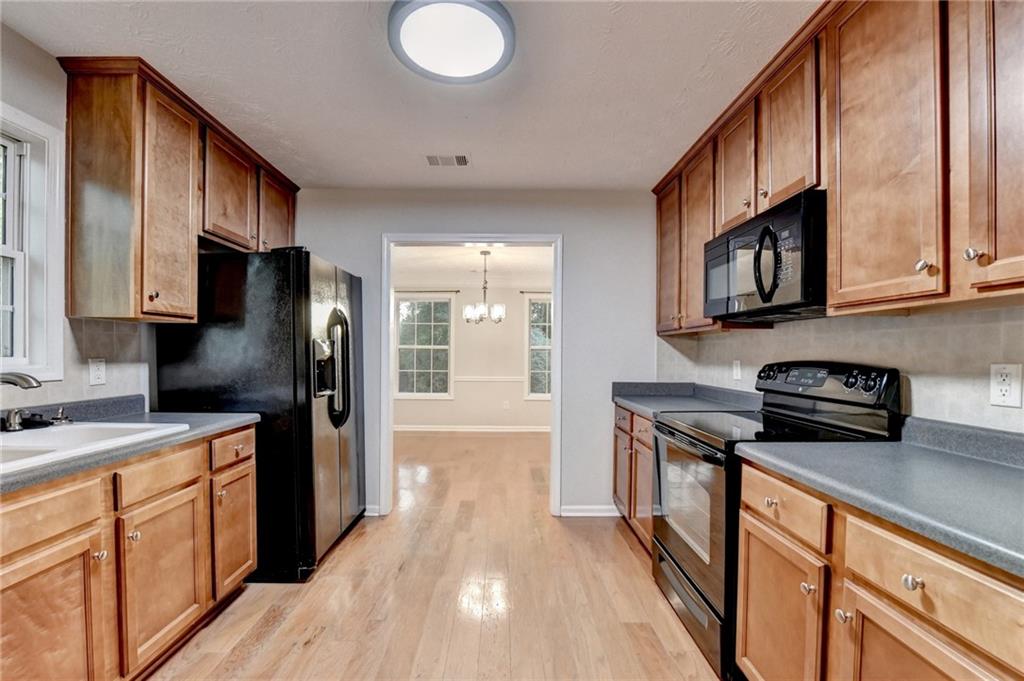 310 Andrew Ridge Drive Jefferson, GA 30549 - Photo 21 of 52 a kitchen with stainless steel appliances granite countertop a refrigerator a stove top oven a sink dishwasher and wooden cabinets with wooden floor