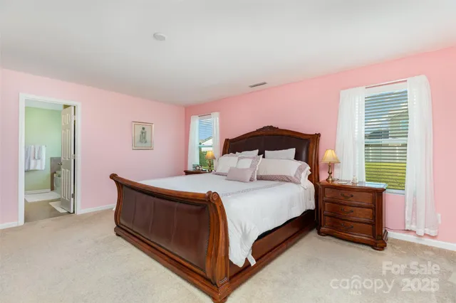 a bedroom with a bed lamp and a large window