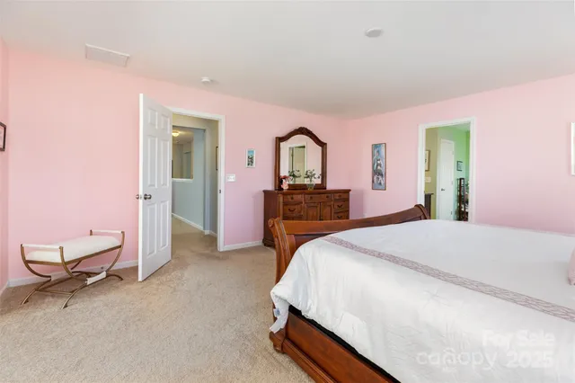 a spacious bedroom with a bed and a dresser