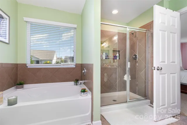 a bathroom with a tub a sink and a large mirror