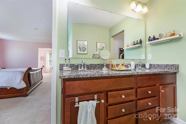 a bathroom with a granite countertop sink and a mirror