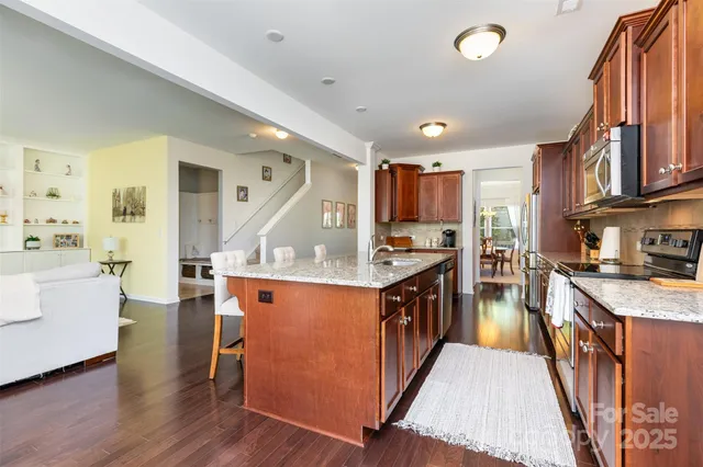 a kitchen with stainless steel appliances granite countertop wooden cabinets sink and stove