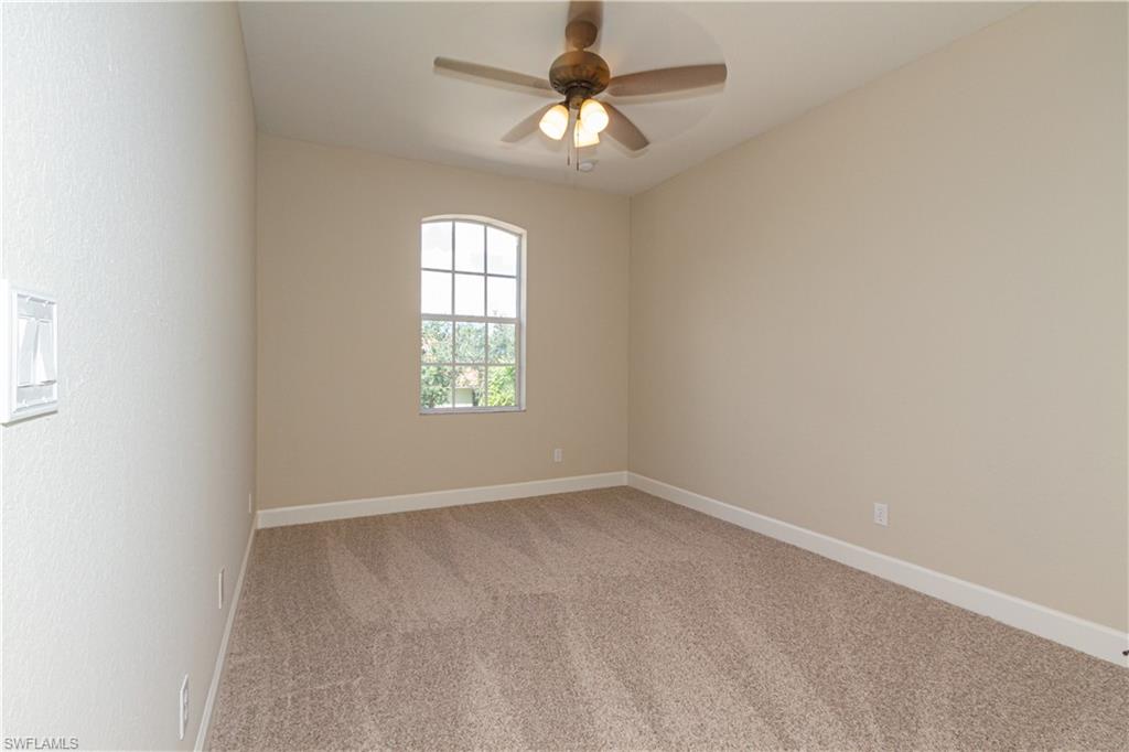 9172 Quartz Lane Naples, FL 34120 - Photo 18 of 25 an empty room with windows and chandelier fan