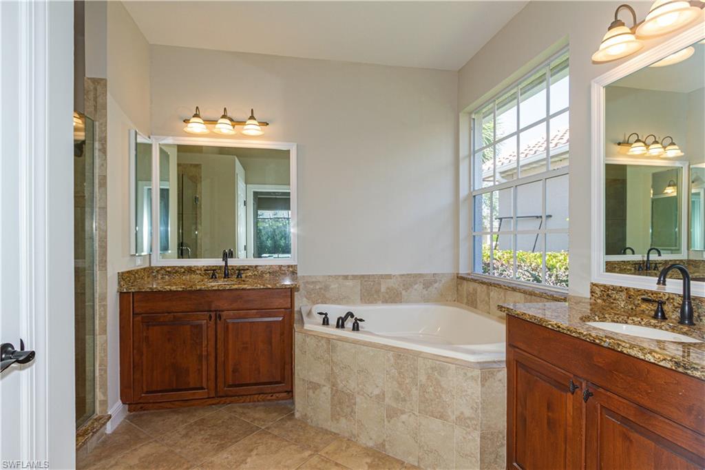 9172 Quartz Lane Naples, FL 34120 - Photo 19 of 25 a spacious bathroom with a tub sink and mirror