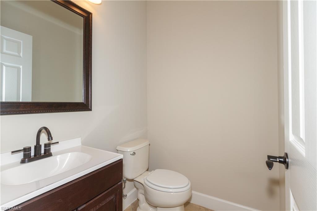 9172 Quartz Lane Naples, FL 34120 - Photo 21 of 25 a bathroom with a toilet a sink and mirror