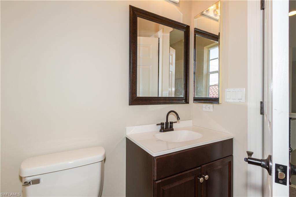 9172 Quartz Lane Naples, FL 34120 - Photo 22 of 25 a bathroom with a toilet sink and mirror