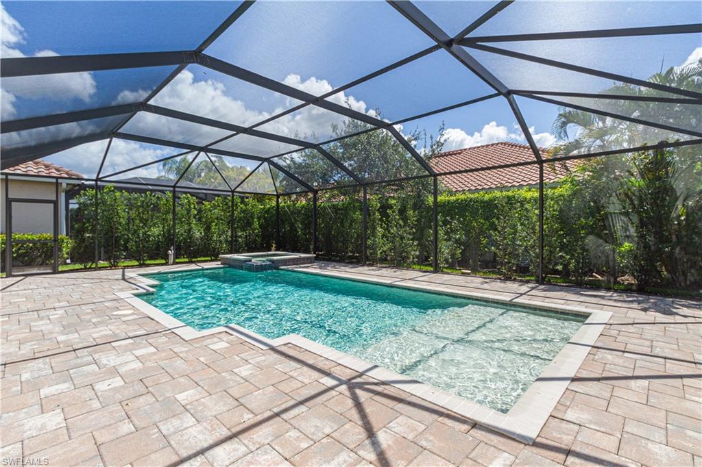 9172 Quartz Lane Naples, FL 34120 - Photo 24 of 25 a view of a backyard with table and chairs under an umbrella