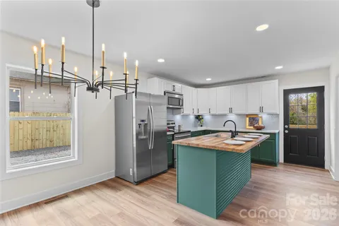 a kitchen with stainless steel appliances granite countertop a sink and a refrigerator