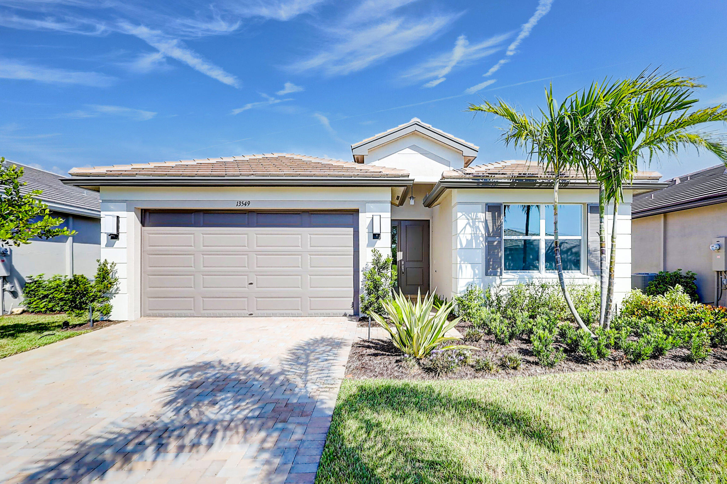 13549 Southwest Oceanus Boulevard Port St. Lucie, FL 34987 - Photo 1 of 30 a front view of a house with a yard