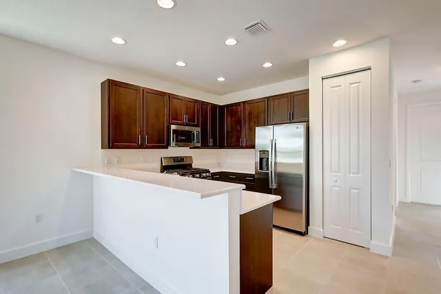 a kitchen with stainless steel appliances a refrigerator sink and microwave