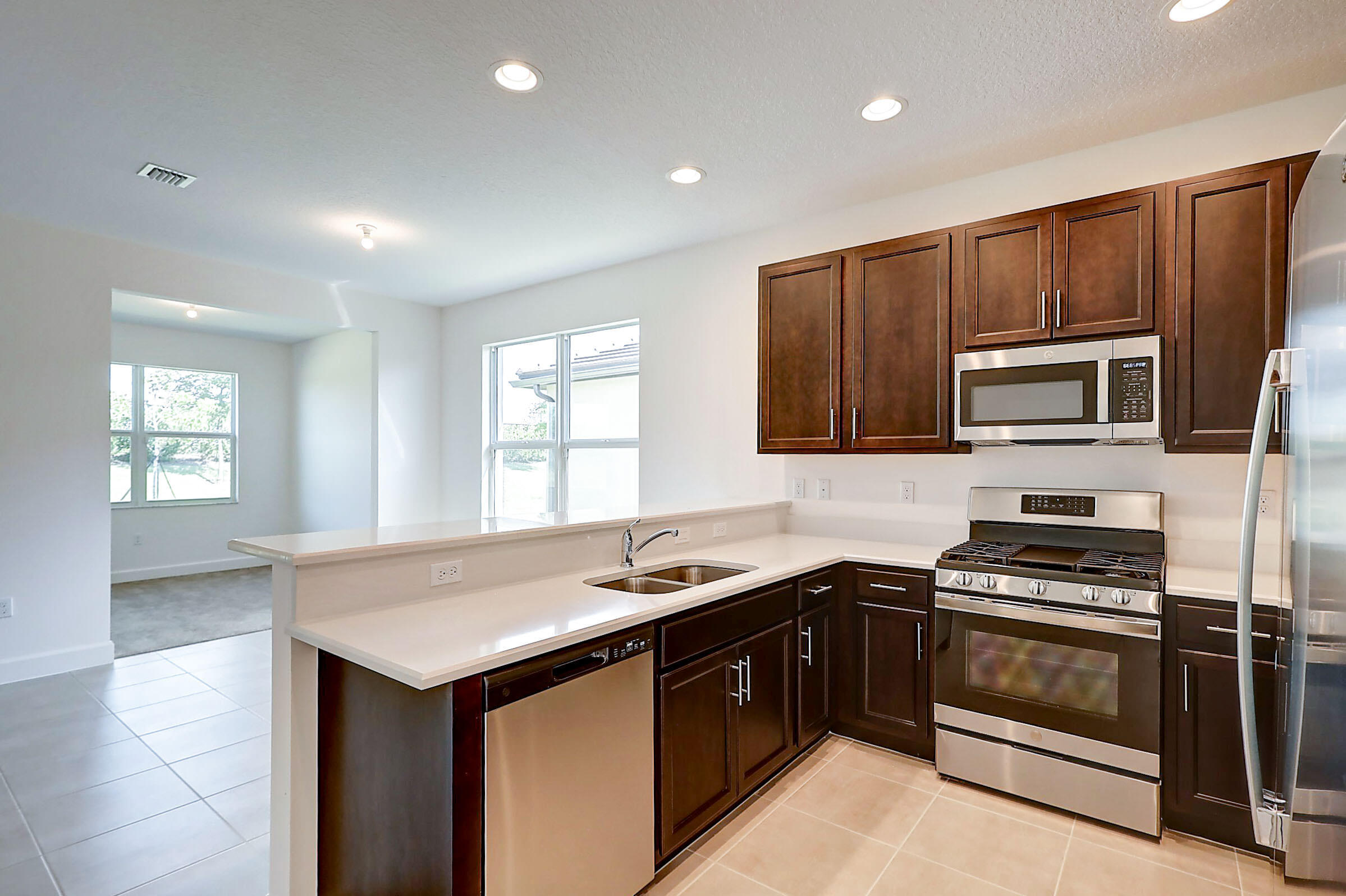 13549 Southwest Oceanus Boulevard Port St. Lucie, FL 34987 - Photo 19 of 30 a kitchen with granite countertop a stove cabinets and microwave