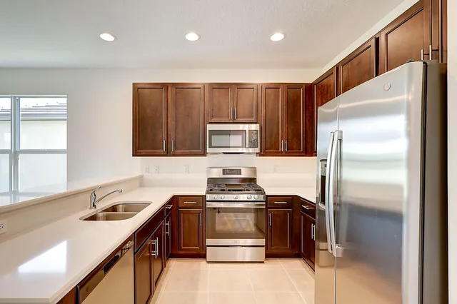 a kitchen with kitchen island stainless steel appliances cabinets a sink and a stove