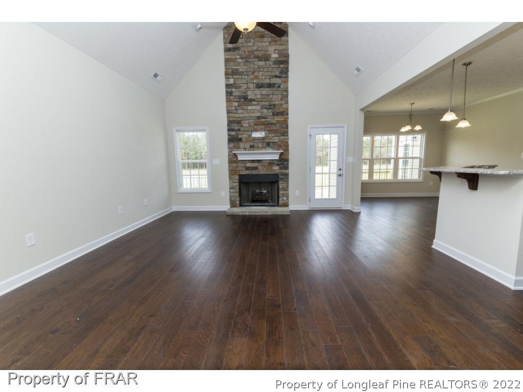 5615 Wade-Stedman Road Wade, NC 28395 - Photo 16 of 36 a view of a livingroom with wooden floor and a fireplace