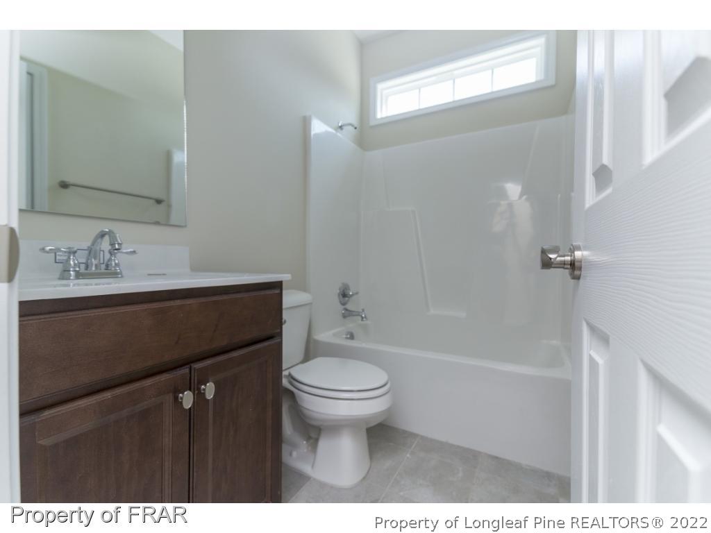 5615 Wade-Stedman Road Wade, NC 28395 - Photo 18 of 36 a bathroom with a sink a toilet a mirror and shower