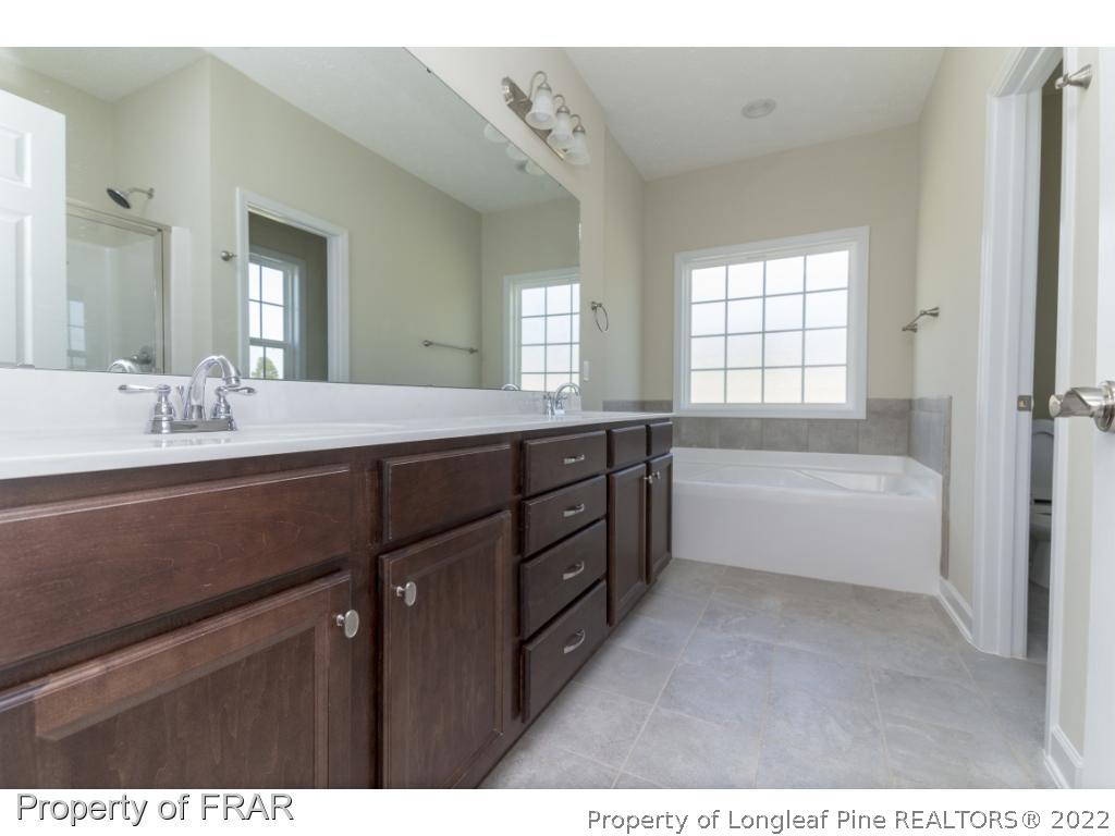 5615 Wade-Stedman Road Wade, NC 28395 - Photo 24 of 36 a spacious bathroom with a tub sink and mirror