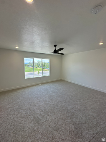 1225 West 500 South Logan, UT 84321 - Photo 32 of 39 Spacious room featuring neutral carpeting, a large multi-pane window, recessed lighting, a ceiling fan, and white baseboards