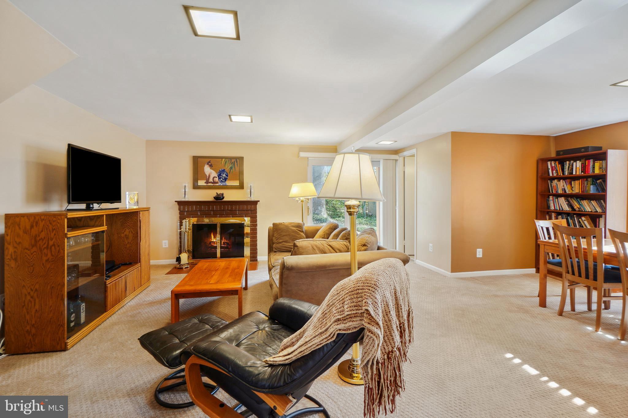 9127 Kirkdale Road Bethesda, MD 20817 - Photo 27 of 34 a living room with furniture a fireplace and a flat screen tv
