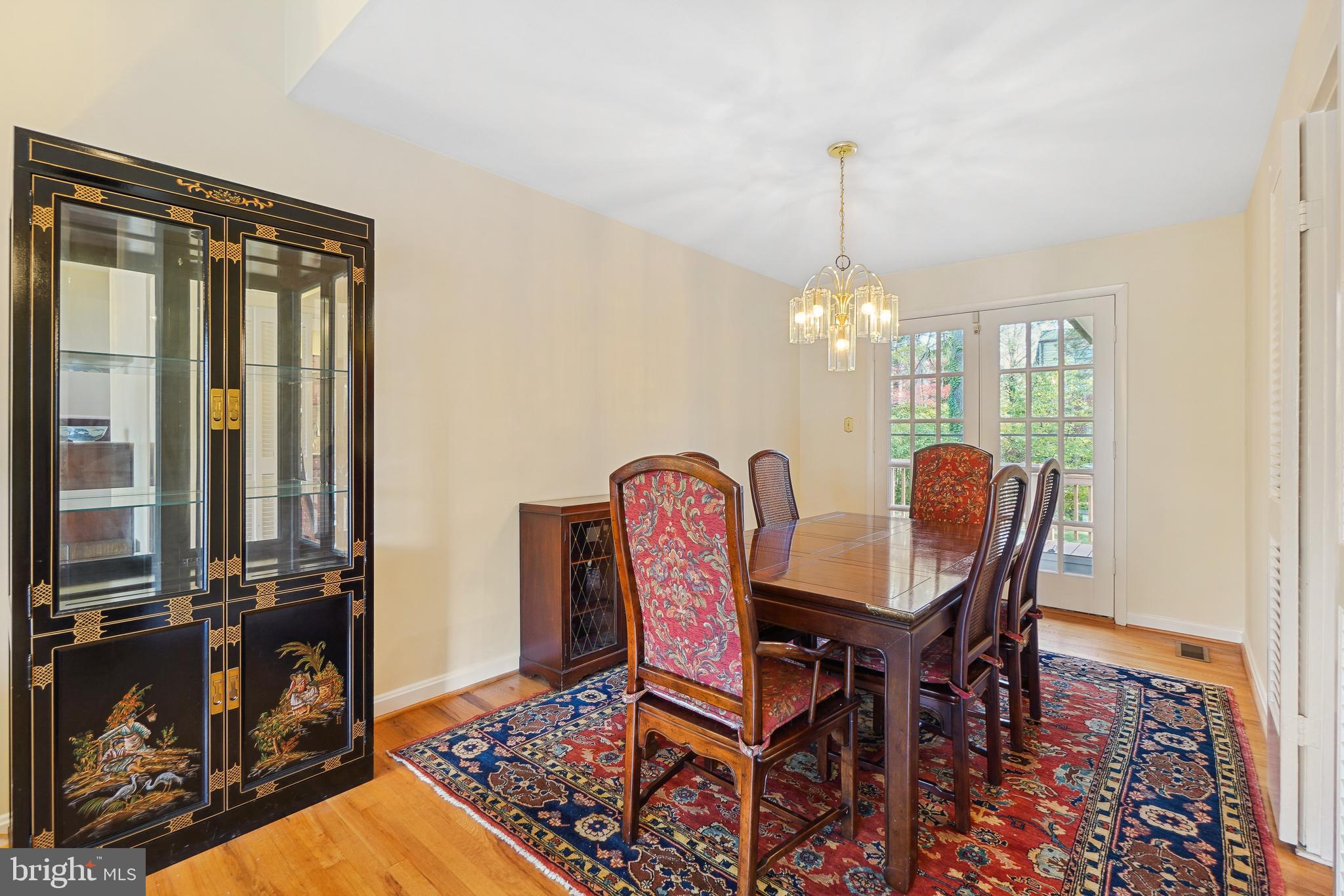 9127 Kirkdale Road Bethesda, MD 20817 - Photo 6 of 34 a dining room with furniture a chandelier and wooden floor