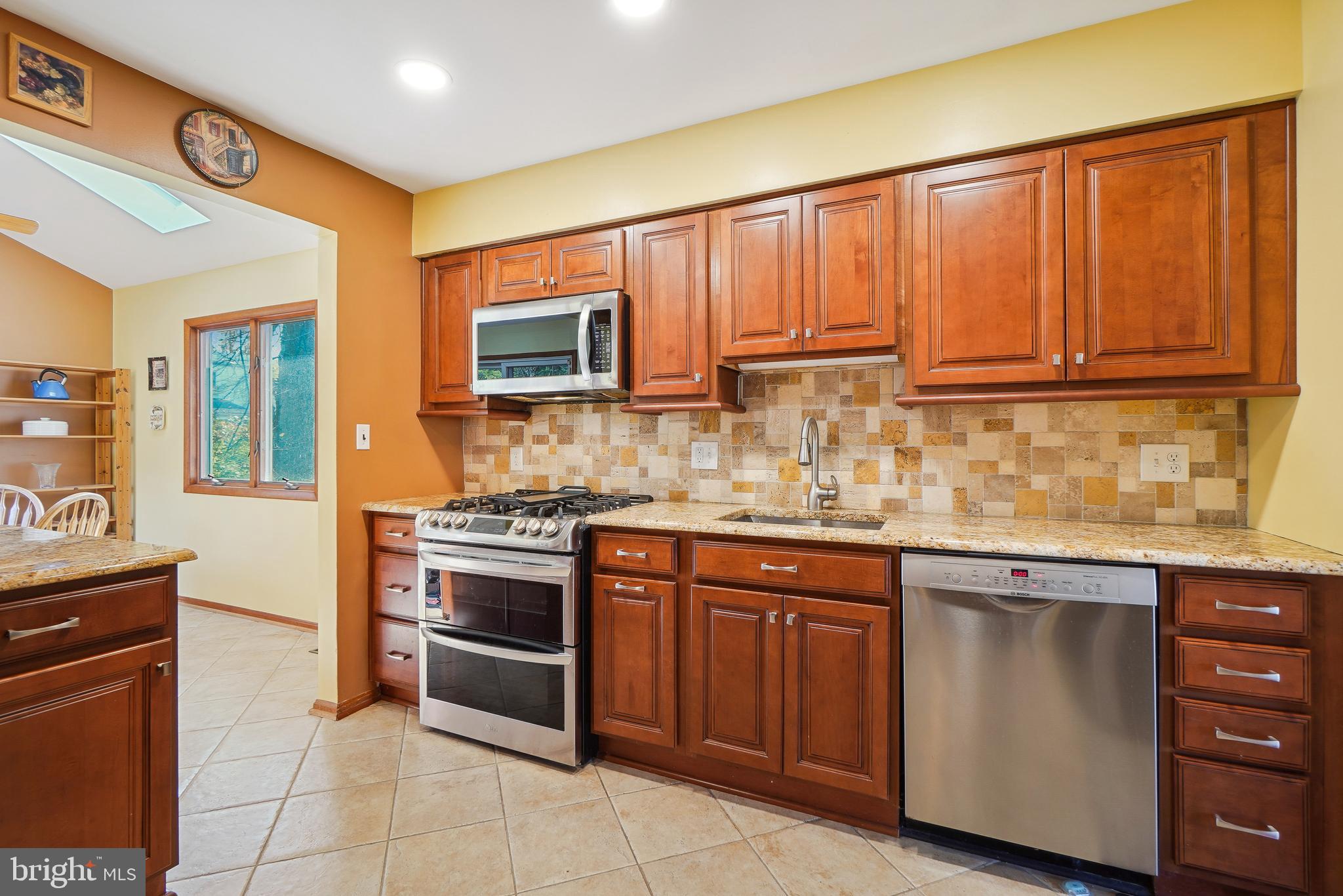 9127 Kirkdale Road Bethesda, MD 20817 - Photo 10 of 34 a kitchen with granite countertop wooden cabinets stainless steel appliances and a counter space