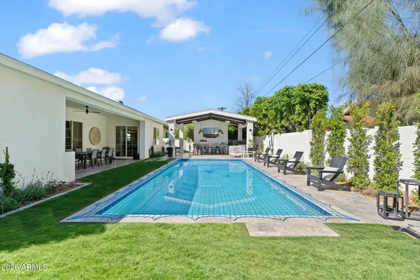 a swimming pool with outdoor seating and yard