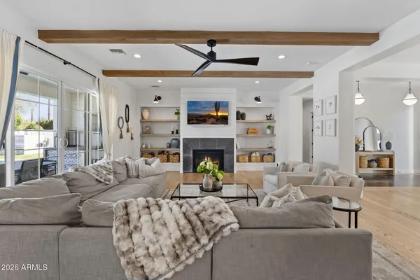 a living room with furniture a fireplace and a chandelier