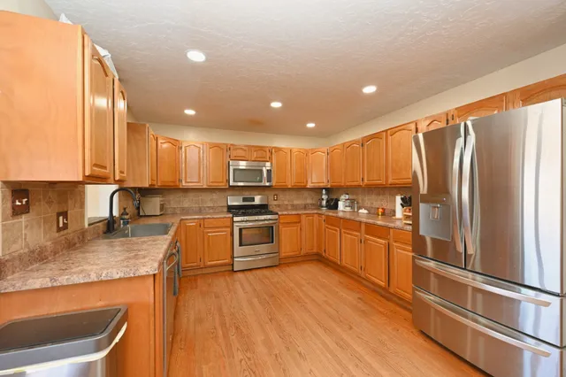 a bathroom with double vanity sink a mirror and a toilet