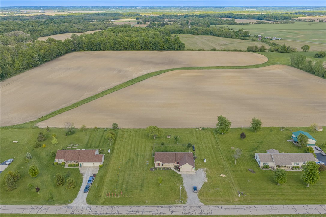 2645 Vance Road St. Paris, OH 43072 - Photo 34 of 35 An aerial perspective reveals multiple rural homes nestled amongst expansive green fields and distant tree lines.