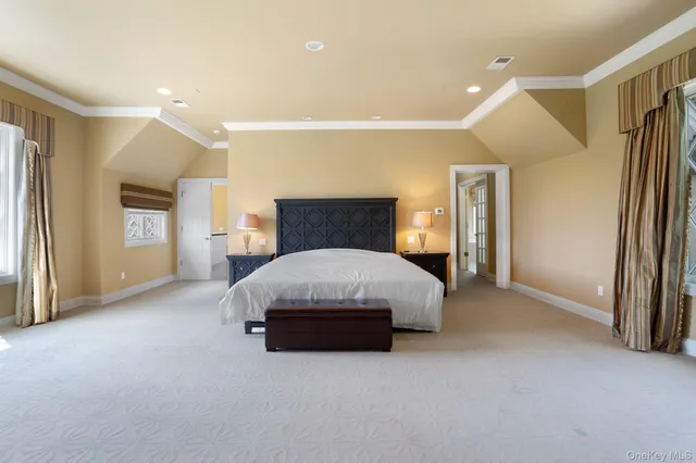 a spacious bedroom with a bed and a cabinets