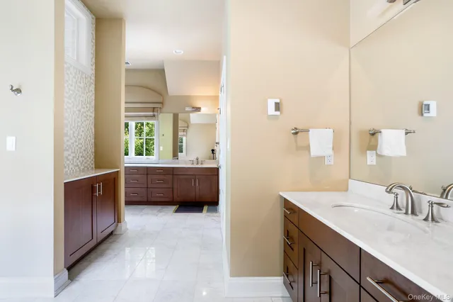 a en suite bathroom with a double vanity sink a mirror and a bathtub