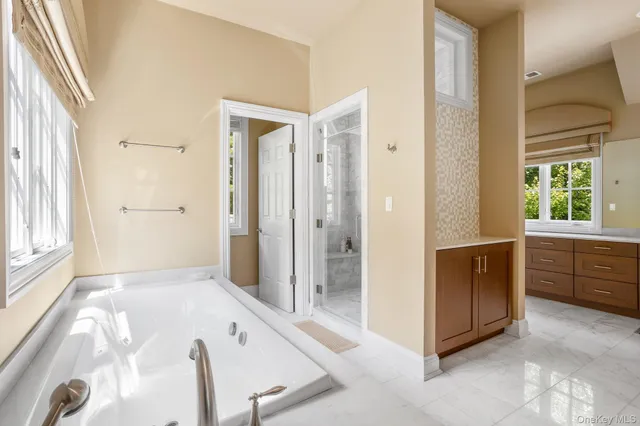 a bathroom with a tub sink and mirror