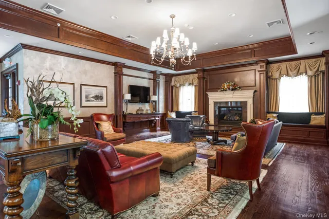 a living room with furniture a chandelier and a fireplace