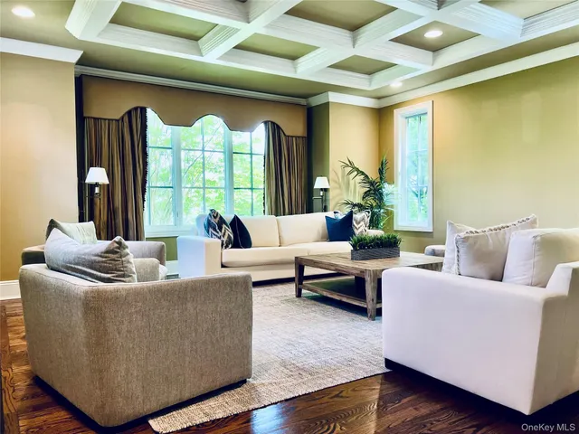 a living room with furniture and a large window with wooden floor