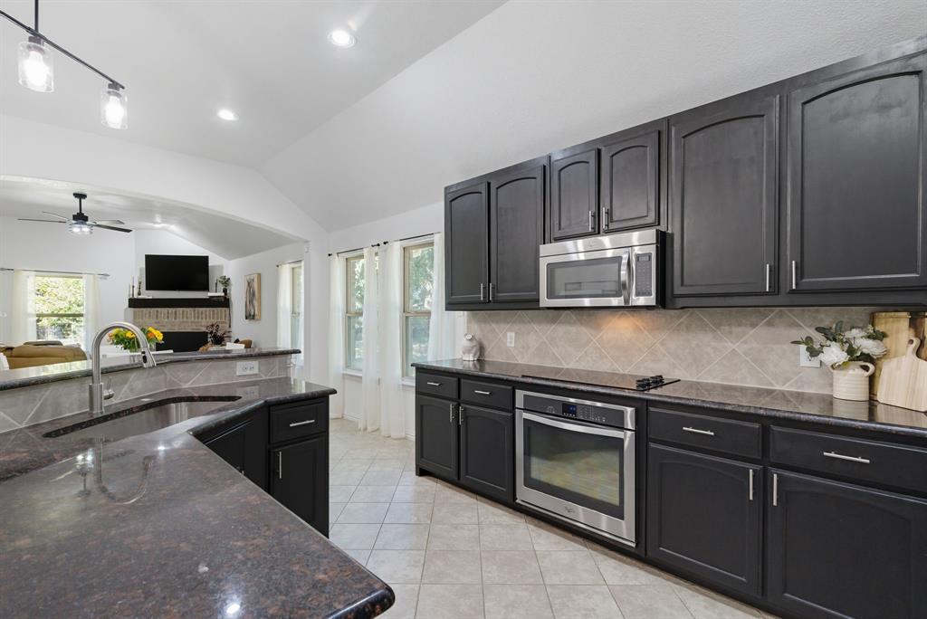 104 Candis Court Springtown, TX 76082 - Photo 39 of 40 a kitchen with stainless steel appliances granite countertop a sink and stove top oven