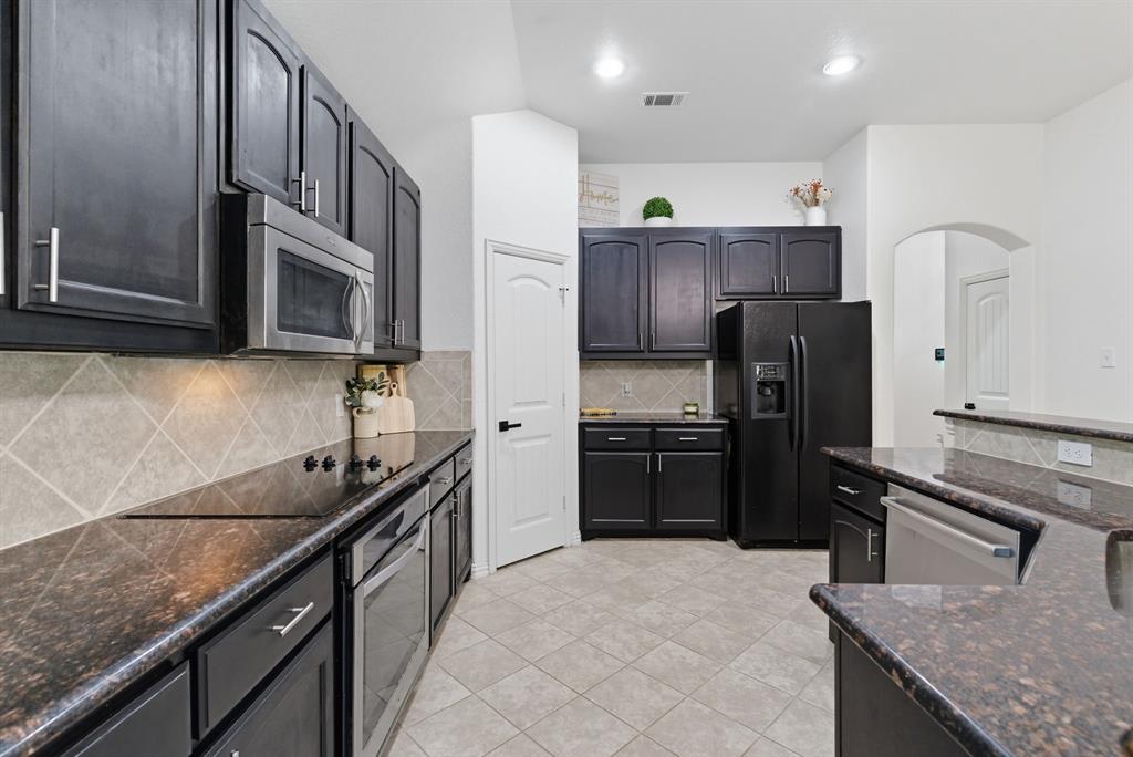 104 Candis Court Springtown, TX 76082 - Photo 10 of 40 a kitchen with stainless steel appliances granite countertop a refrigerator a stove a sink and a microwave