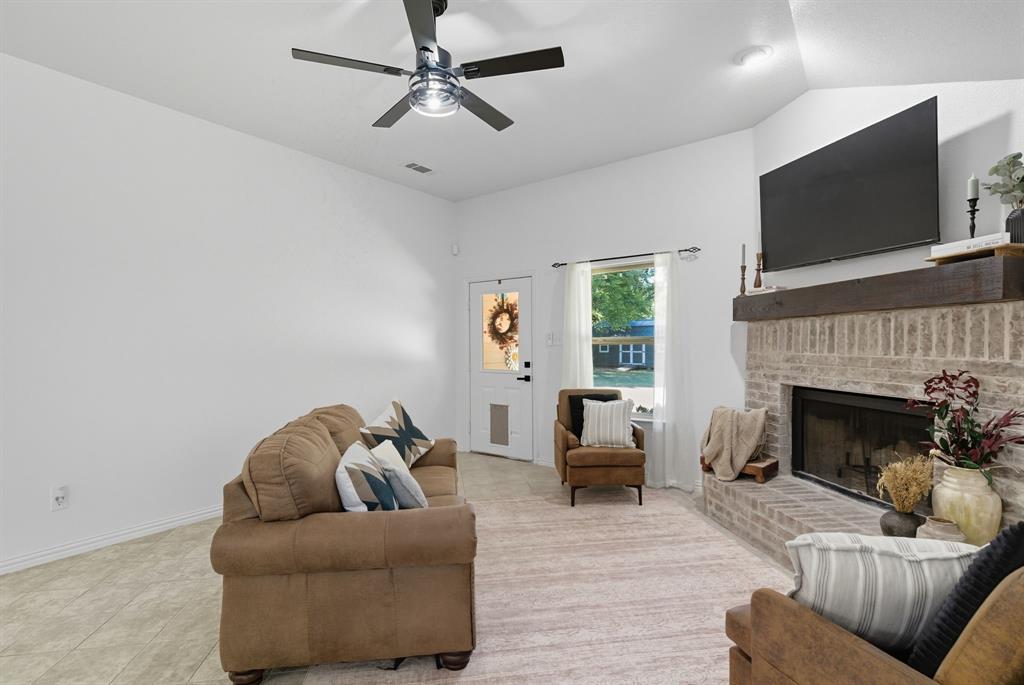 104 Candis Court Springtown, TX 76082 - Photo 15 of 40 a living room with furniture a flat screen tv and a fireplace