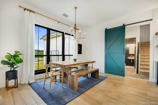 a living room with furniture large window and wooden floor