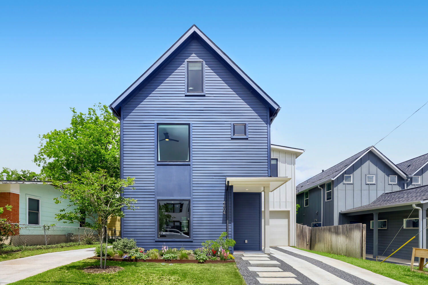 The property features a blue exterior with horizontal siding and a prominent gable roof
