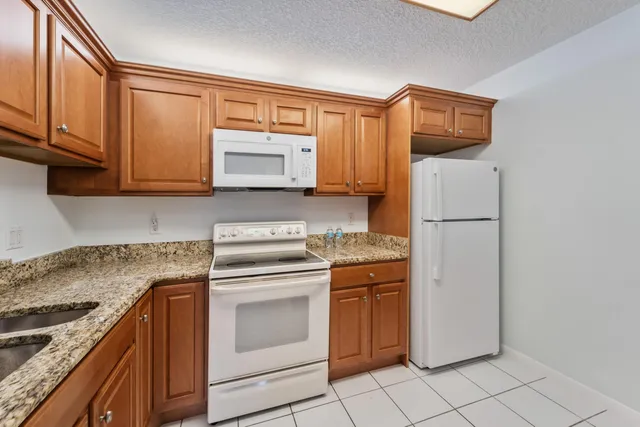 a kitchen with stainless steel appliances granite countertop a sink and dishwasher a stove top oven with white cabinets