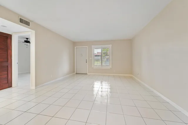 an empty room with closet and windows