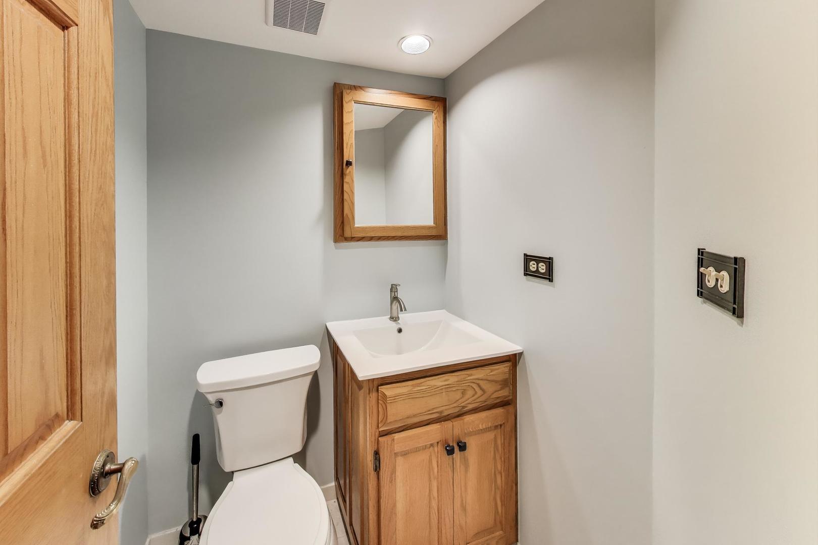 821 South Racine Avenue, Unit D Chicago, IL 60607 - Photo 14 of 14 a bathroom with a toilet sink vanity and mirror
