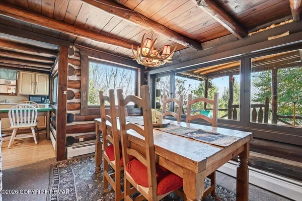 a kitchen with stainless steel appliances granite countertop a stove top oven a dining table and chairs with wooden floor